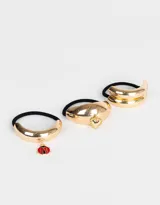 Set de tres gomitas de pelo elásticas negras con apliques dorados: dos con cuff de metal dorado y una con dije de cerezas.