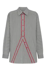 Camisa de poplin negro rayado con corte cómodo, mangas 3/4 y detalles ondeados al frente con zigzag de algodón fucsia y botones fucsia.