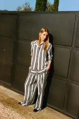 Pantalón amplio de tiro alto con cintura elástica y cordón de ajuste. Diseño a rayas verticales en blanco y negro.