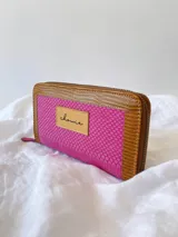 Billetera de cuero fucsia y marrón con cierre metálico y monedero interno.