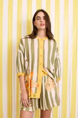 Camisa ancha estampada con corte holgado y mangas abullonadas, color verde y blanco a rayas verticales con detalles florales y botones amarillos.