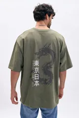 Remera verde militar de corte holgado con cuello redondo y mangas cortas. Estampa frontal con texto vertical en japonés y un dragón.