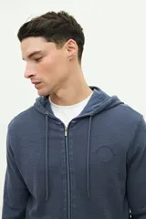 Campera verde militar de felpa con capucha ajustable y cierre frontal. Tiene un pequeño logo estampado en el pecho.