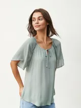 Blusa blanca de mangas cortas con escote redondo y lazos.