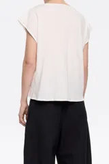 Camiseta de algodón color blanco, de corte recto, con escote redondeado pronunciado, manga corta murciélago, logo handmade y pespuntes a contraste.