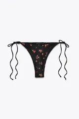 Braguita de bikini negra con estampado de flores rojas, de tiro medio y cintura ajustable con lazos.