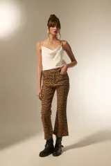 Pantalón de jean estampado camuflado en tonos marrón y beige, de corte flare y tiro alto.