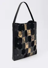 Bolso tipo shopper con estampado animal print, confeccionado con piezas de cuero bovino, ovino y caprino unidas con anillas metálicas.