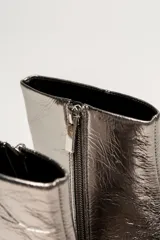 Bota corta de cuero negro con punta fina y taco bajo rectangular.