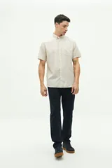 Camisa de manga corta color beige claro, confeccionada en lino y algodón, con fit regular y logo bordado en el pecho.