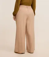 Pantalón de corte ancho confeccionado en sastrería de viscosa color beige, con cintura alta, trabillas, cierre con botón forrado y bolsillos laterales.