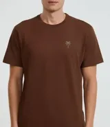 Remera marrón de algodón, corte comfort, con cuello redondo y mangas cortas. Presenta un pequeño estampado de palmera en el pecho.