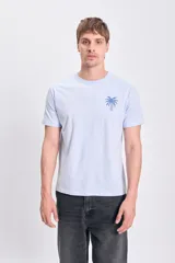 Remera celeste de manga corta con estampa de una palmera en el pecho.