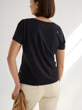 Remera gris de manga corta con cuello redondo y líneas verticales en blanco y negro. Corte recto y holgado. Confeccionada en algodón y spandex.