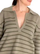 Sweater de punto color crema con rayas horizontales negras, cuello polo con escote en V y mangas largas.