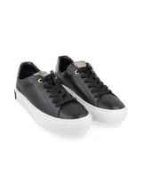 Zapatillas urbanas de cuero negro con suela blanca y detalle plateado en el talón.