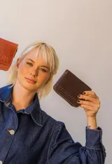 Billetera de cuero color tostado con cierre de cremallera. Interior con seis compartimentos para tarjetas y un compartimento para monedas con cierre. El billete entra doblado.