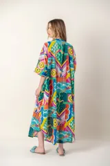 Vestido largo con estampado de peces azules sobre fondo blanco, cuello en V y mangas cortas.