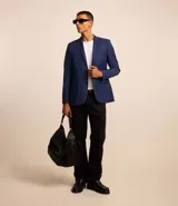 Saco de traje azul cobalto, modelo social, con cuello solapa, abotonado delantero, bolsillos y mangas largas.