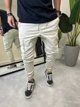 Pantalón jogger cargo color beige de gabardina, con puños elásticos y cordón ajustable en la cintura.