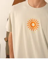 Remera unisex color crema con estampado de un sol anaranjado.