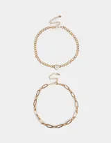 Set de dos chokers dorados con diferentes cadenas de eslabones. Uno de los chokers tiene un dije de reloj con forma de corazón.