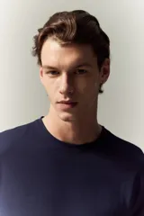 Remera azul marino de punto de algodón liviano, con cuello redondo ribeteado y bajo recto. Corte ajustado que realza el contorno del cuerpo creando una silueta entallada.