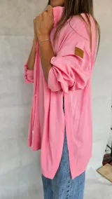 Camisa negra de corte amplio, con mangas largas y puños abotonados.