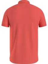 Chomba Tommy Hilfiger de corte slim, color salmón, con cuello clásico, cartera de dos botones y logo de la marca bordado en el pecho.