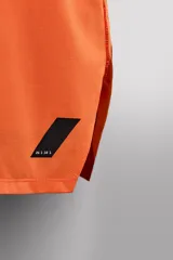 Camiseta deportiva sin mangas color beige, confeccionada en tejido técnico ligero y elástico con estructura perforada. Tiene cuello redondo amplio, sisas con acabados termofijados, bajo con aberturas laterales y logo estampado.