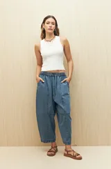 Pantalón gris oscuro de denim con corte holgado, cintura elastizada con cordón y ruedo con dobladillo.