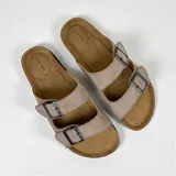 Sandalias planas color beige con doble tira y hebillas metálicas ajustables.