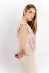 Blusa blanca de algodón con escote en V, volados en el frente y mangas cortas.