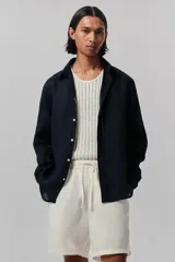 Short blanco de lino y algodón, con corte relajado, cintura elástica con cordón ajustable, bolsillos laterales y bolsillo trasero insertado.