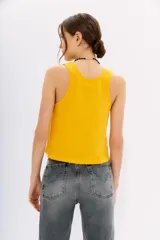 Musculosa amarilla de algodón con escote redondo pronunciado y corte holgado.