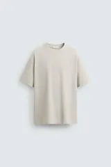 Camiseta color crema de corte holgado, cuello redondo y manga corta.