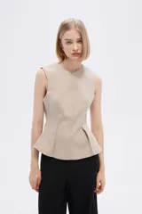 Blusa color crudo sin mangas con peplum.
