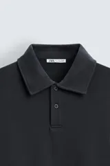 Polo manga larga negro de algodón con elasticidad y estructura. Cuello solapa con cierre frontal de botonadura y acabados con rib.