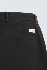 Pantalón chino color beige, corte skinny fit, confeccionado en tejido con mezcla de algodón y elasticidad. Cuenta con bolsillos frontales y traseros. Cierre frontal con cremallera y botón.