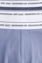Pack de tres calzoncillos tipo trunk en azul, blanco y azul marino, con cintura elástica blanca con la inscripción "Designed in Stockholm Est. 1947". Confeccionados en tejido funcional COOLMAX® y Lycra® Xtra Life™.