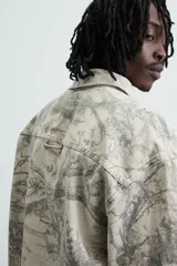 Sobrecamisa relaxed fit de algodón con cuello solapa, manga larga con puños abotonados, bolsillos de plastrón en el pecho, efecto lavado y cierre frontal abotonado. Estampado abstracto en tonos grises.