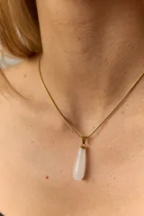 Collar dorado con cadena fina y dije colgante en forma de lágrima de piedra natural azul con vetas blancas.