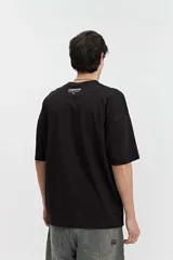Remera de manga corta color marrón claro, de corte amplio y cuello redondo.