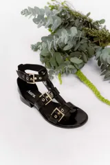 Sandalia de cuero vacuno color negro con múltiples tiras y hebillas metálicas ajustables. Taco bajo de 2 cm, forro y plantilla de cuero, suela sintética.