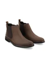 Bota corta tipo Chelsea de cuero marrón oscuro, con elástico lateral en color marrón más oscuro y suela de goma negra de bajo perfil.