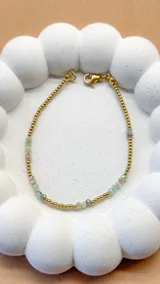 Pulsera elástica con cuentas facetadas de ágata color miel y pequeñas esferas de acero dorado.
