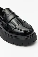 Mocasines negros de símil cuero con plataforma chunky de 4cm y detalle de flecos. 