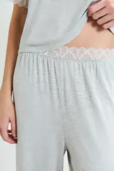 Conjunto de pijama negro, compuesto por una remera de manga corta con detalle de encaje en los puños y un pantalón largo de corte recto.