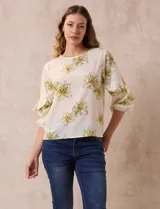 Blusa de gasa color crema con estampado de flores amarillas, de la marca Sioni. Tiene mangas 3/4 con volados y cuello redondo.