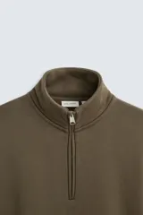 Sudadera negra de algodón con cuello alto y cierre de cremallera frontal. Corte relaxed fit, manga larga y terminaciones en rib.